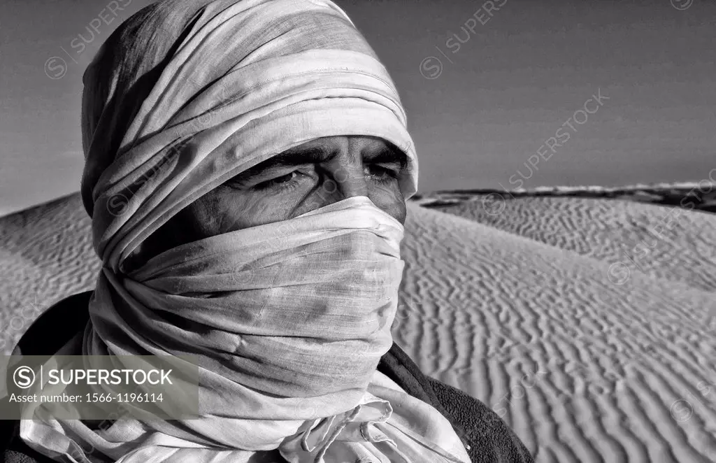 Graphic portrait of Bedouin man in Sahara Desert with sand in Douz Tunisia Africa