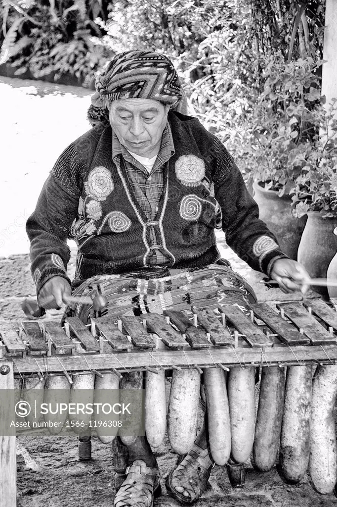 Old woman playing ancient instrument harp in village of Chichicastenango Guatemala