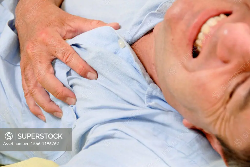 Man experiencing pain in his chest  This may be due to angina or a heart attack