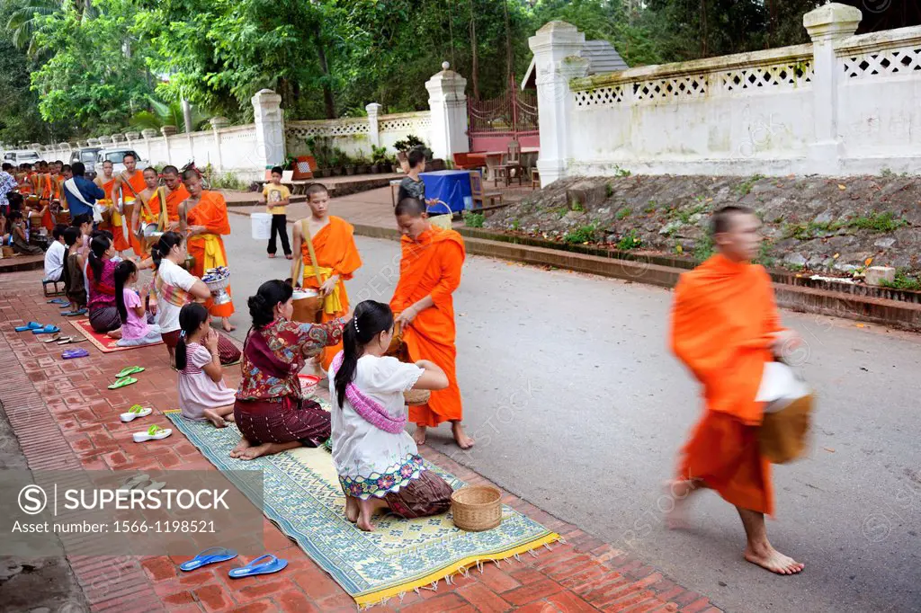 Luang Phabang, Laos-July 22, 2009  Every day very early in the morning, hundreds of monks walk the streets to beg