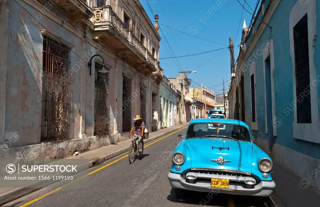 Camaquey Cuba street scene of old Oldsmobile car on street and buildings