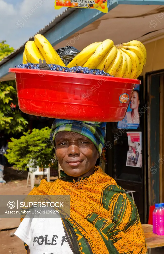 Mosquito Village Mto wa Mbu Tanzania Africa village woman with bananas on head for sale to tourists 4