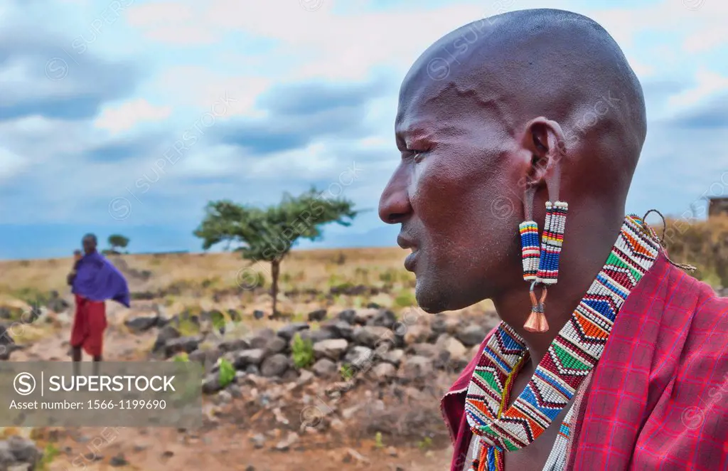 Kenya Africa Amboseli Maasai tribe village Masai man in red costume dress and beads close up of jewelry in remote area of Amboseli National Park safar...
