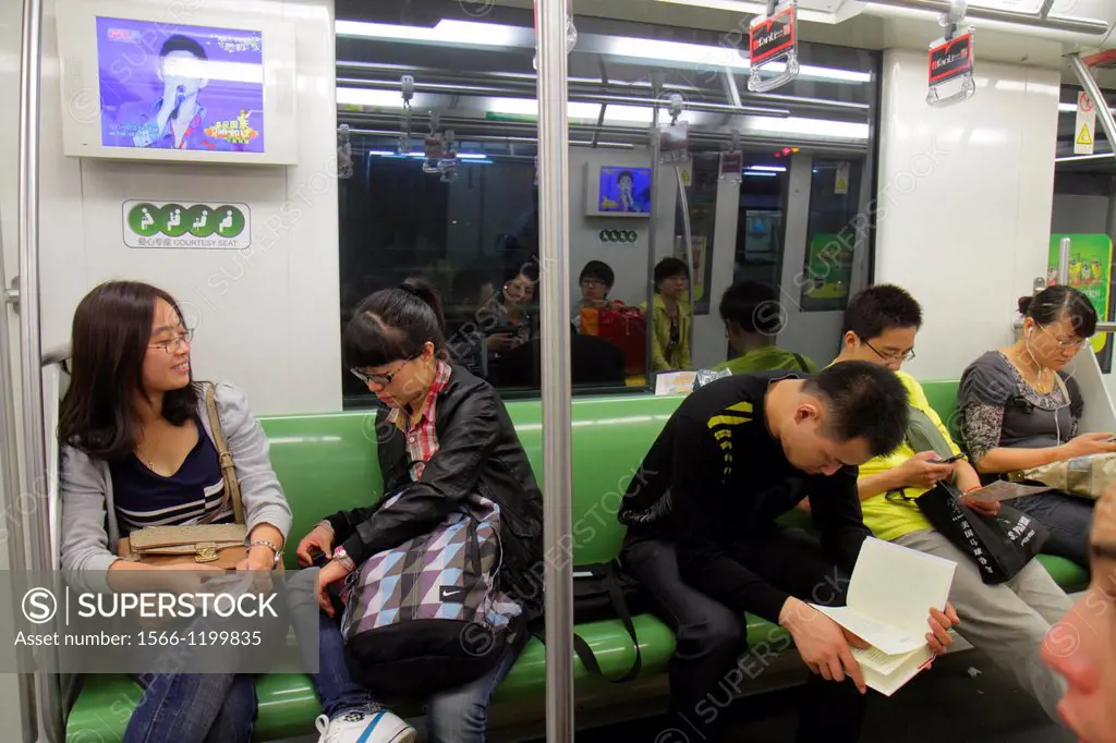 China, Shanghai, Metro, subway, public transportation, riders, Asian, man, woman, Green Line 2, reading,