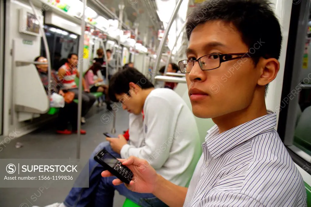 China, Shanghai, Metro, subway, public transportation, riders, Asian, man, Green Line 2, using smartphone, BlackBerry,