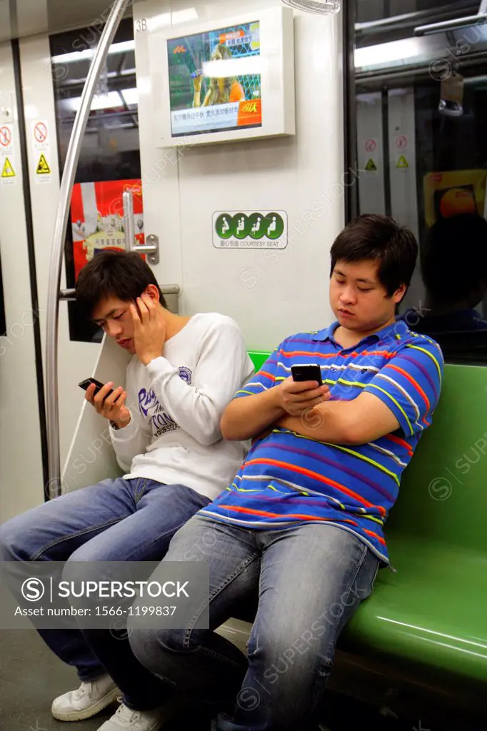 China, Shanghai, Metro, subway, public transportation, riders, Asian, man, Green Line 2, using smartphone, texting,