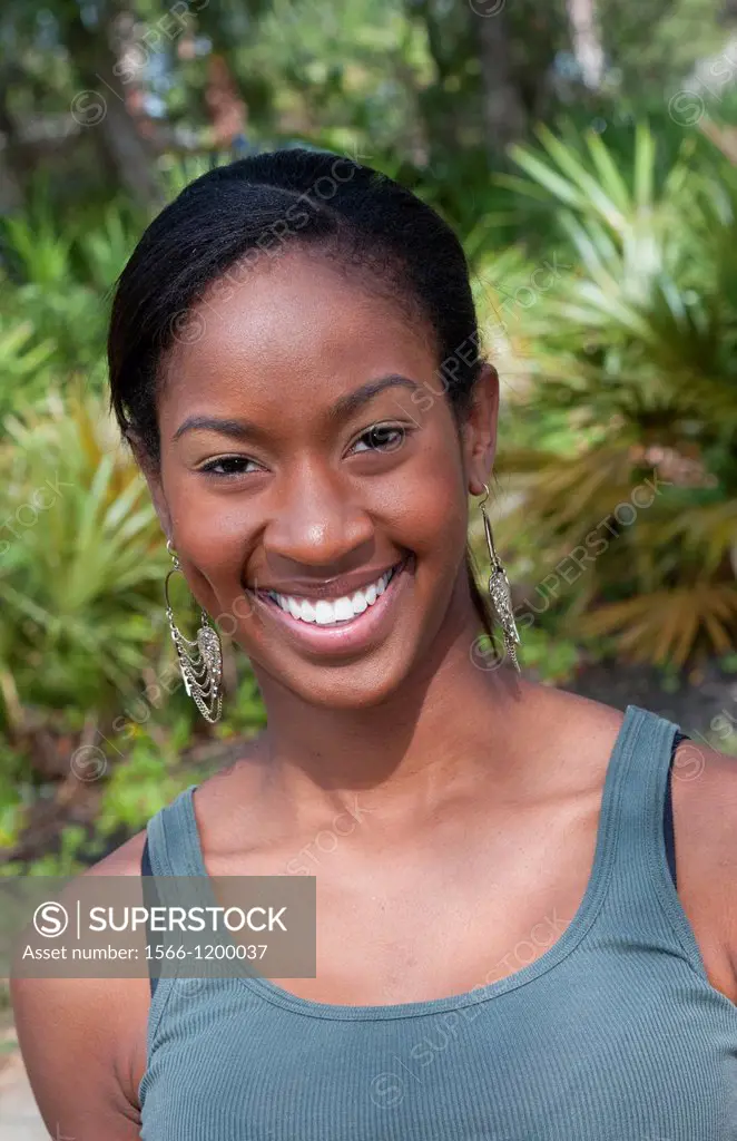Black African American girl aged 18 portrait in yard outdoors laughing