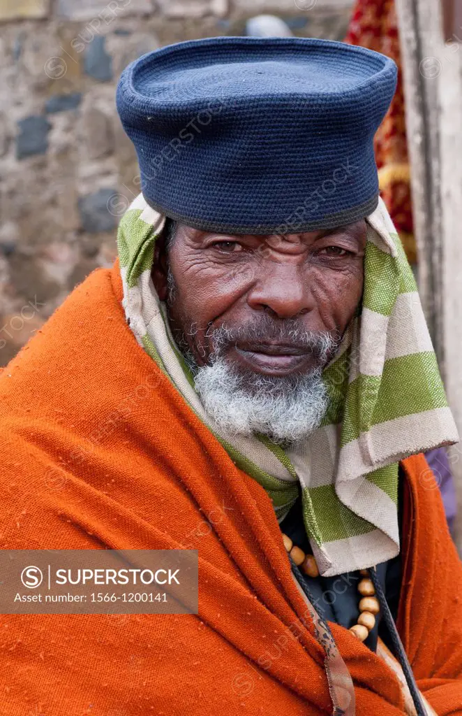 Addis Ababa Ethiopia Africa old religious man portrait aged 70 in orange and robe in Shero Meda area 2