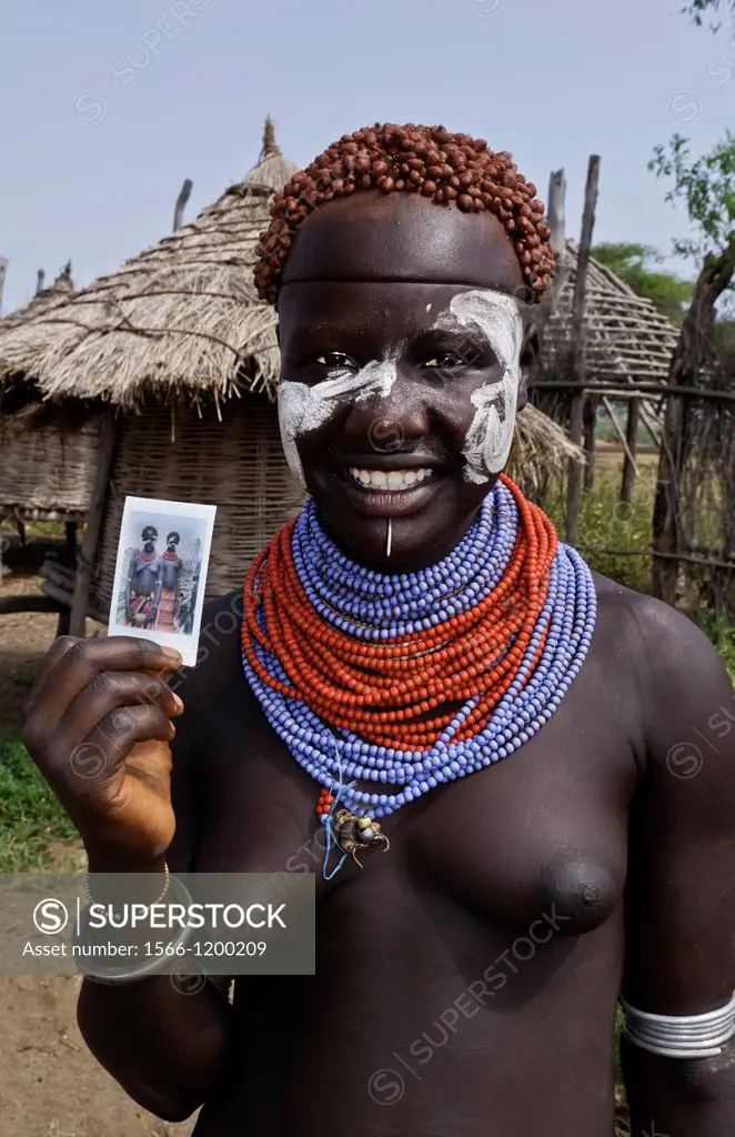 Korcho Ethiopia Africa village Lower Omo Valley Karo tribe with painted faces with red curled hair and proud of new Fuji Polaroid 25