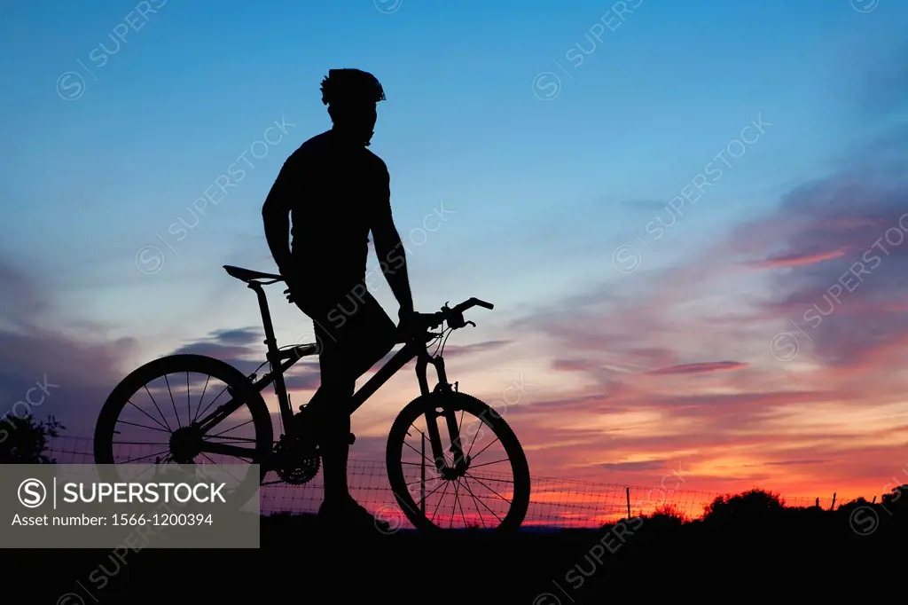 Mountain bike rider resting at dusk