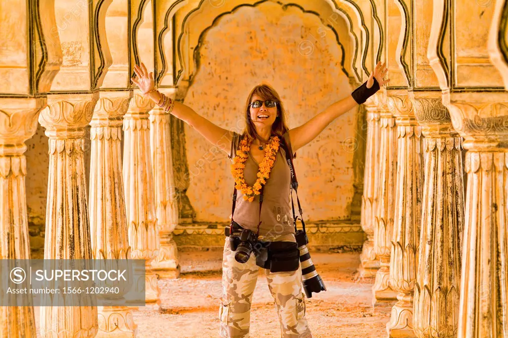 Tourist woman with cameras celebrating traveling to India at Amber Fort in Jaipur Rajasthan India