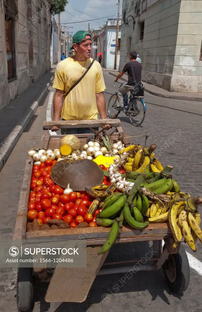 Sancti Spiritus Cuba street scene of man with cart selling fruit
