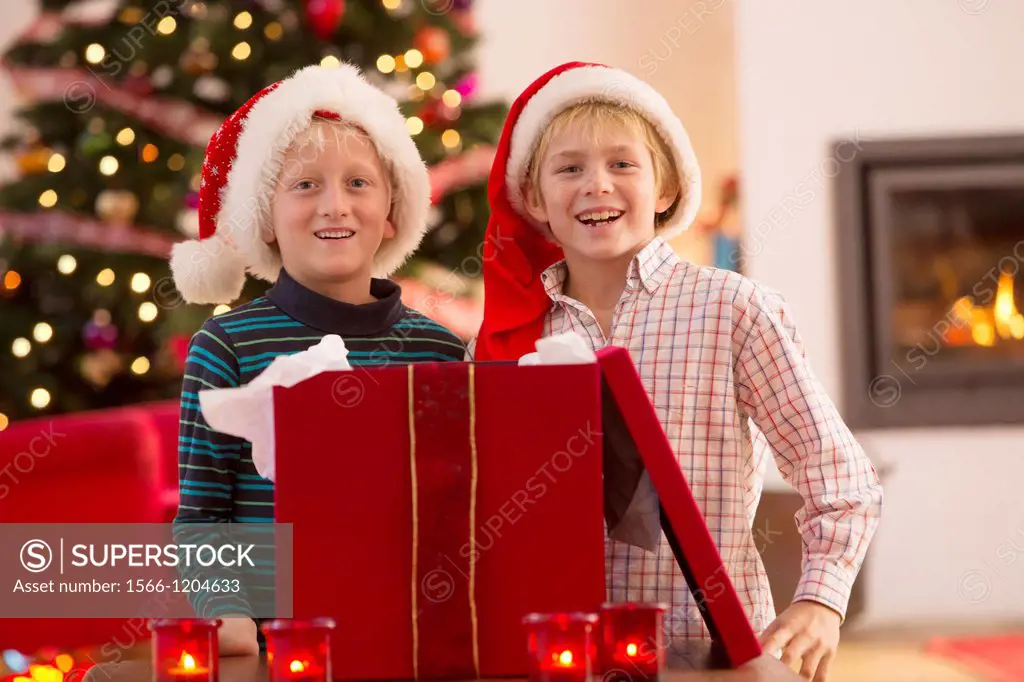 Two young boys opening a Christmas present on Christmas day