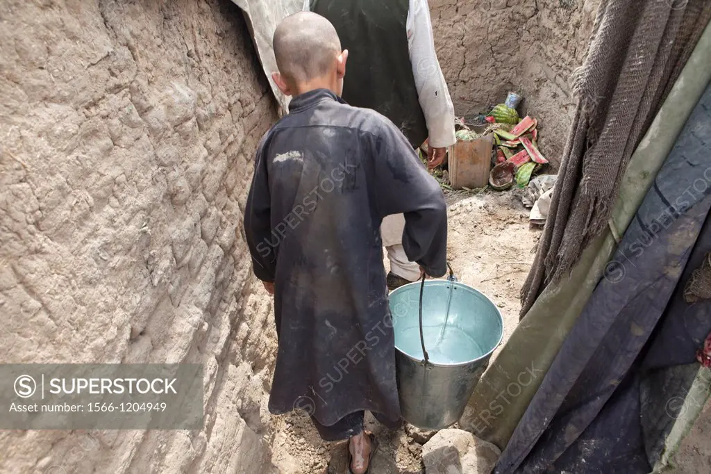Afghan refugee child fetching water from the well