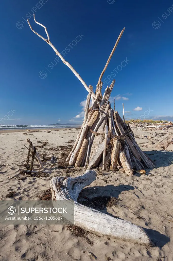 A teepee constructed of driftwood offers protection from the wind, Bandon, Oregon