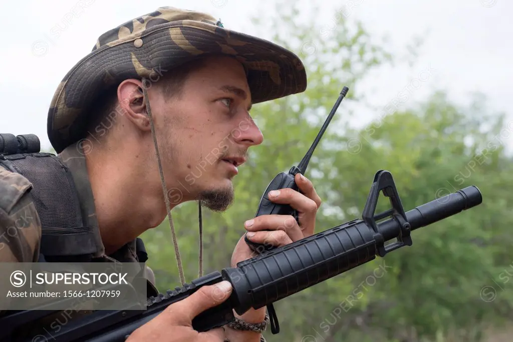 Anti-poaching trainees, using hand held radio during a tracking exercise in the bush