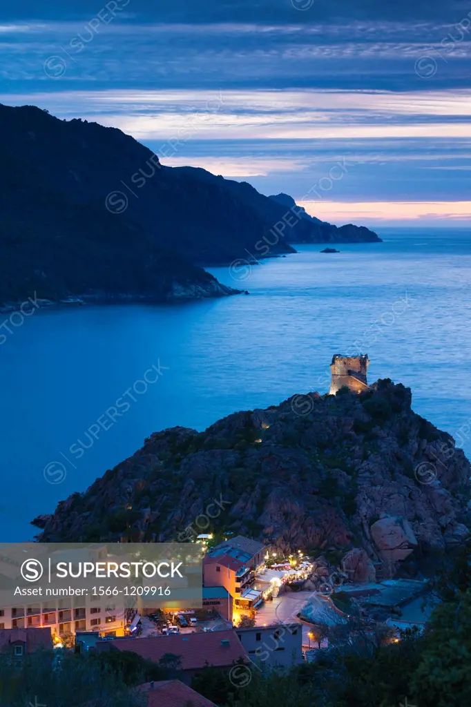 France, Corsica, Corse-du-Sud Department, Calanche Region, Porto, elevated view of town and Genoese tower, dusk