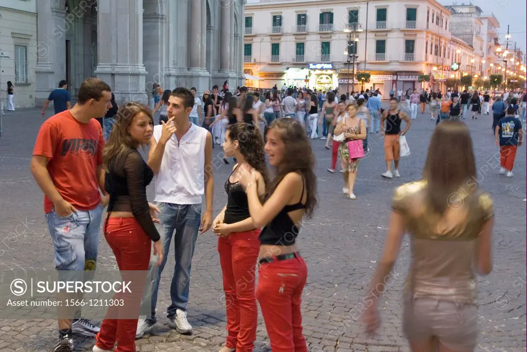 group of young people at dusk in the main street of Pompei, Naples province, Campania region, southern Italy, Europe