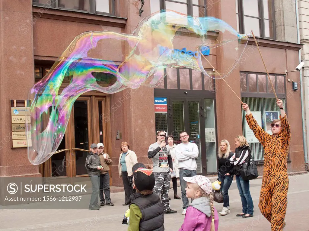 Street artist disguised as a tiger producing giant soap bubbles, Riga, Latvia