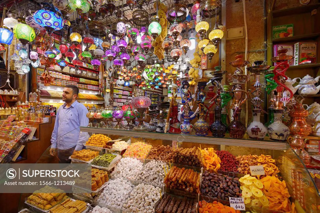 Shop worker in the Egyptian Spice Bazaar Istanbul with Turkish Delight water pipes and lamps