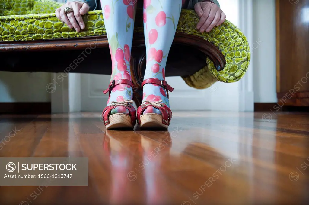 primer plano de piernas con sandalias rojas de mujer sentada, close up of legs of woman sitting with red sandals
