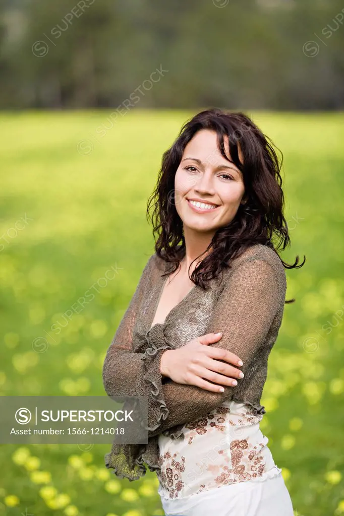 Pretty brunette woman in countryside smiling at camera