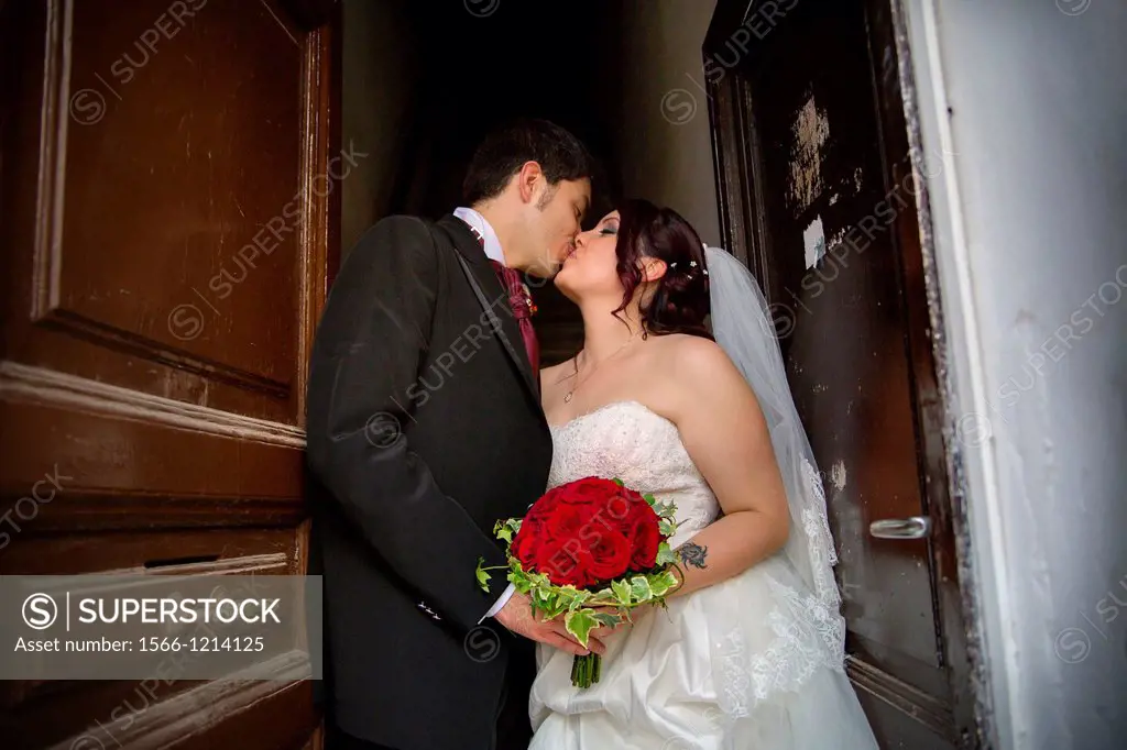 Wedding couple kissing on a doorstep