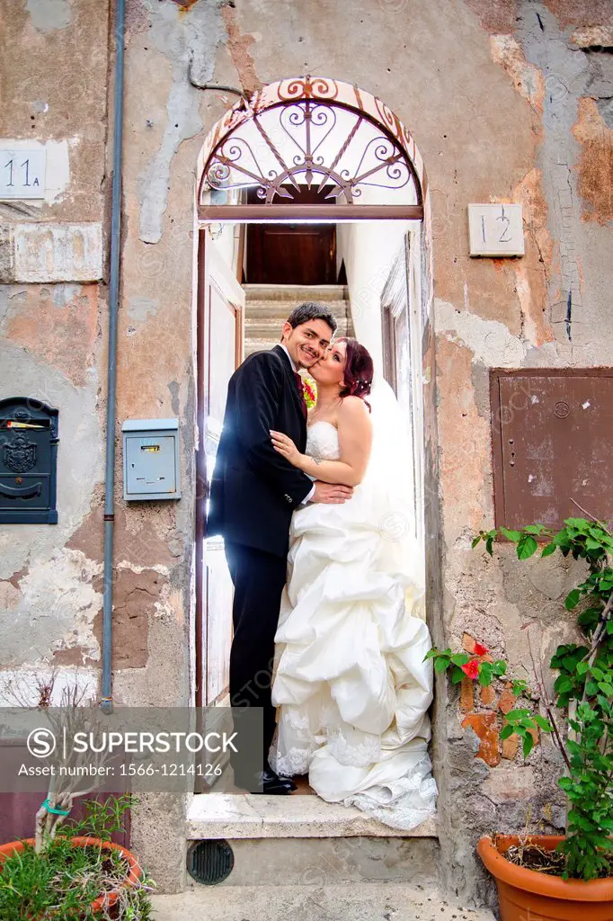 Wedding couple kissing on a doorstep