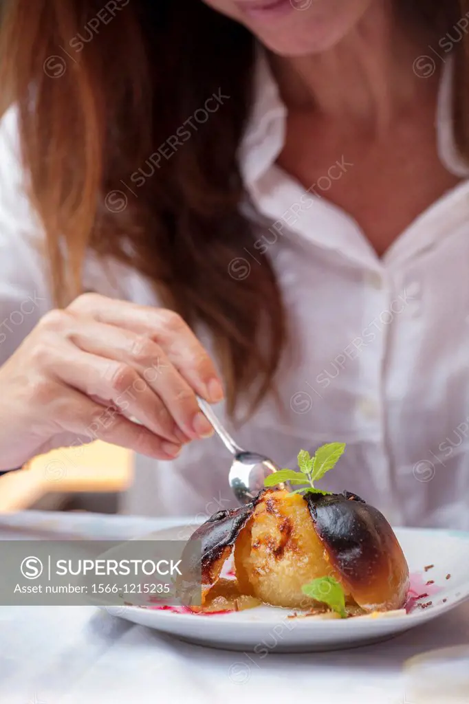 Woman eating baked apple.