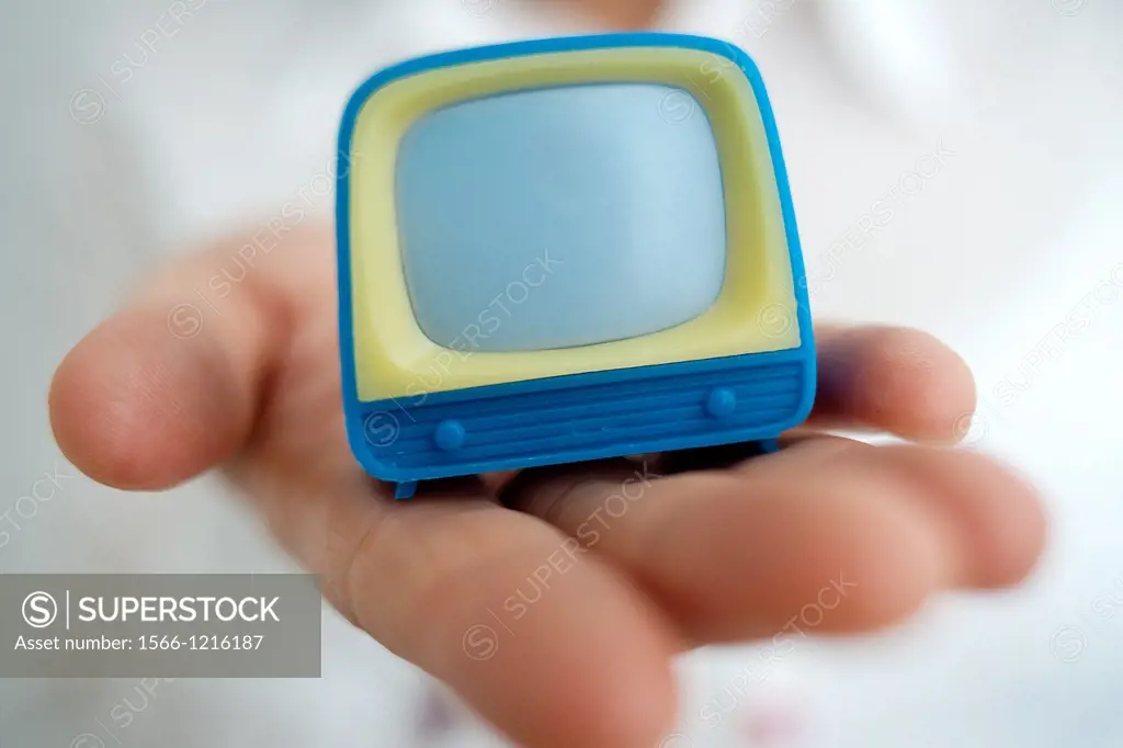 primer plano de mano mostrando un televisor de juguete, close-up of hand showing a TV toy,