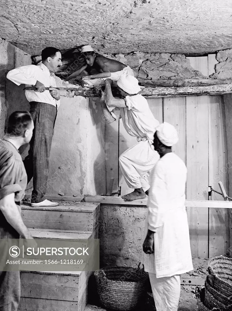 Howard Carter who discovered Tutankhamun´s Tomb in the Valley of the Kings, Luxor, Egypt  November 1922  Carter using a pry bar inside the tomb  From ...