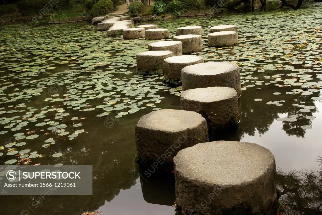 Stepping stones over a water lily pond in a zen garden at the Heian Shrine in Kyoto Japan
