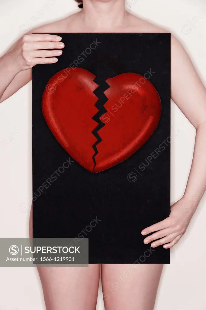 Woman holding a blackboard with a broken heart drawn on it in chalk  Concept image