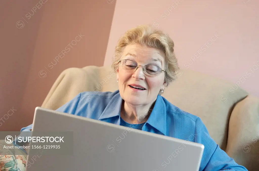 Mature woman using laptop and smiling