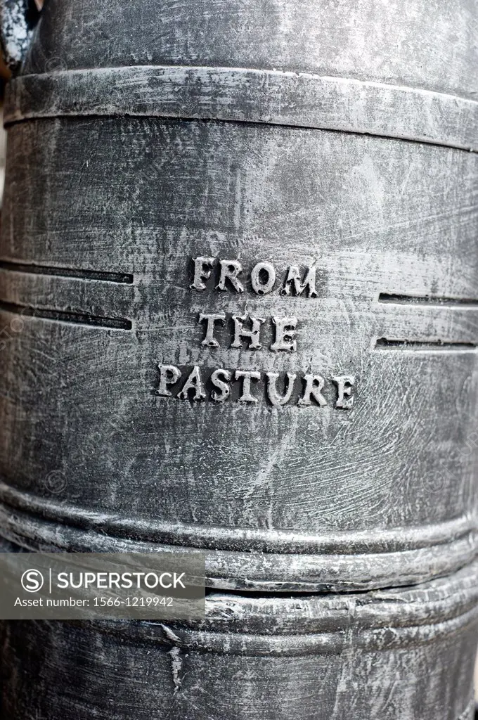 Close up detail of a milk churn with the words FROM THE PASTURE embossed on it