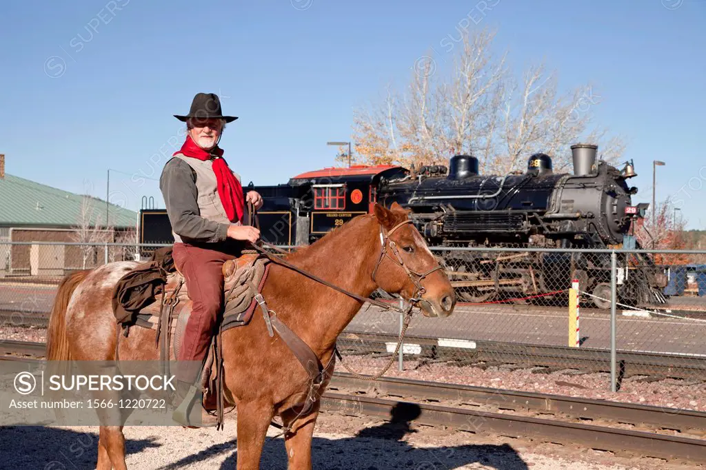 cowboy on his horse and the historic steam railway locomotive Grand Canyon Railway in Kingman, Arizona, United States of America, USA