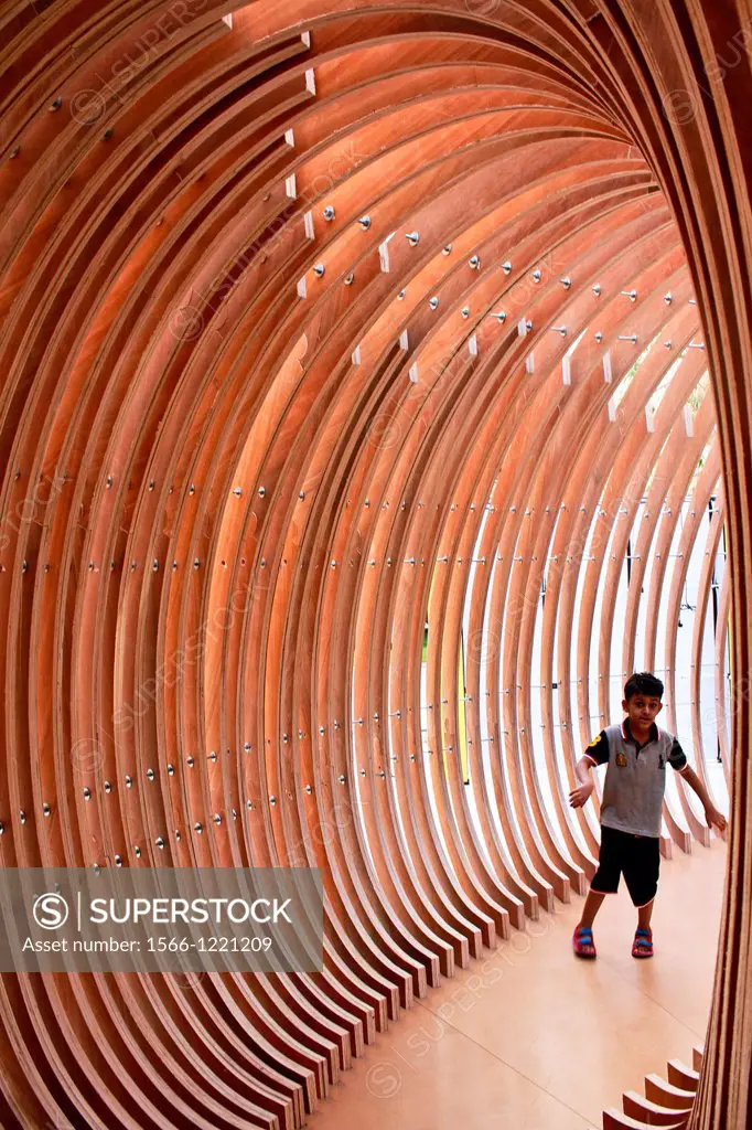 Child walking and play inside modern wood Sculpture, Kuwait
