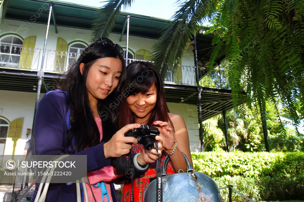 Florida, Florida Keys, Key West, Whitehead Street, The Ernest Hemingway Home & and Museum, Asian, woman, front, exterior, camera, looking,