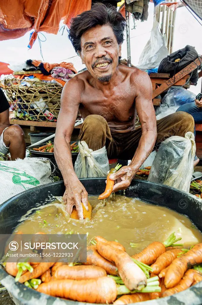 Man washing carrots in a bowl of dirty water, Carbon market, Visayas, Philippines, South East Asia