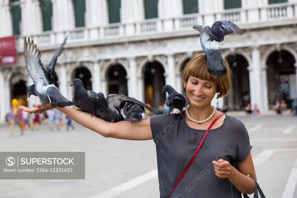 Woman feeding pigeons. Piazza San Marco. Venice Italy.