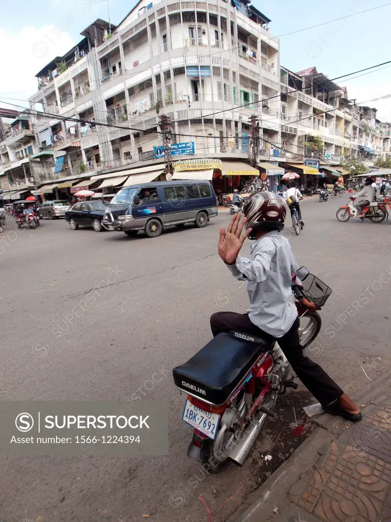 Cambodian motorcycle parked at the intersection of a busy street in Phnom Penh Cambodia