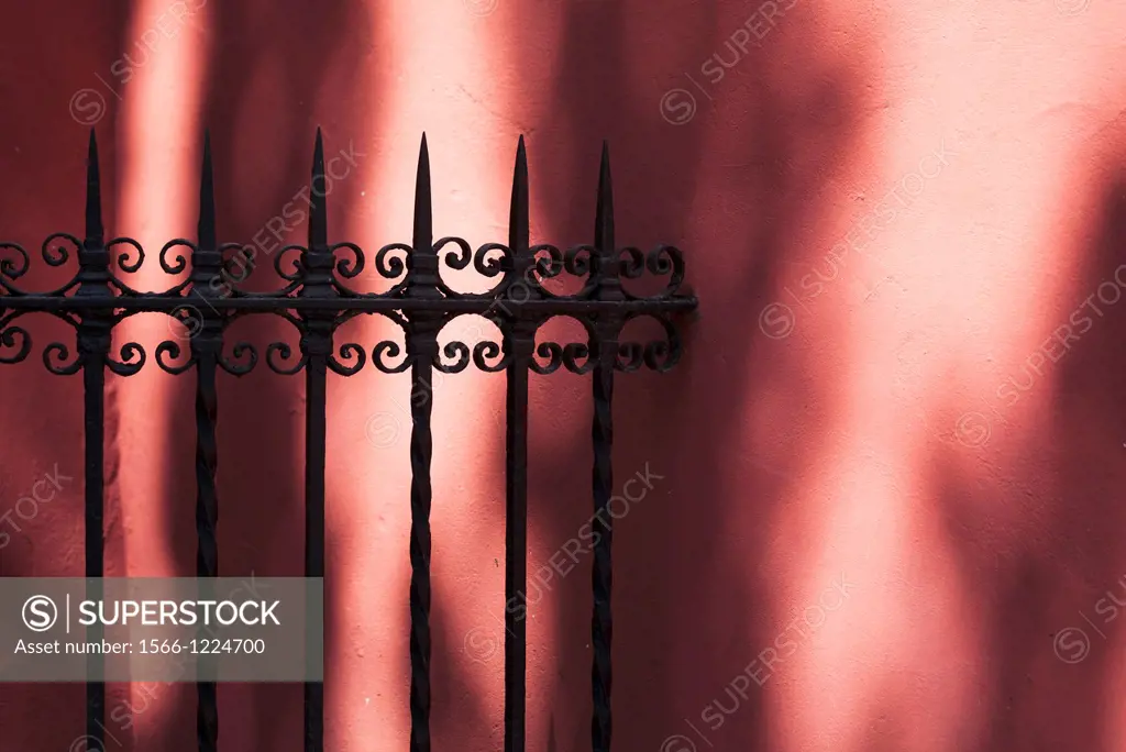 iron fence detail in red wall, Sevilla, Andalucia, Spain, Europe