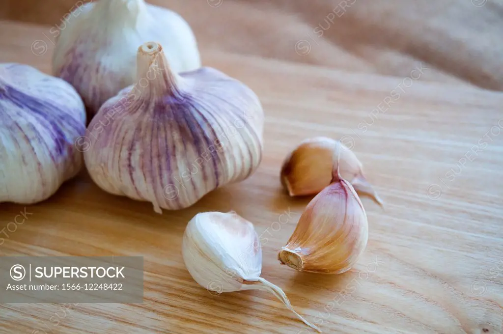 Still life: garlics on a wooden chopping board. Close view.