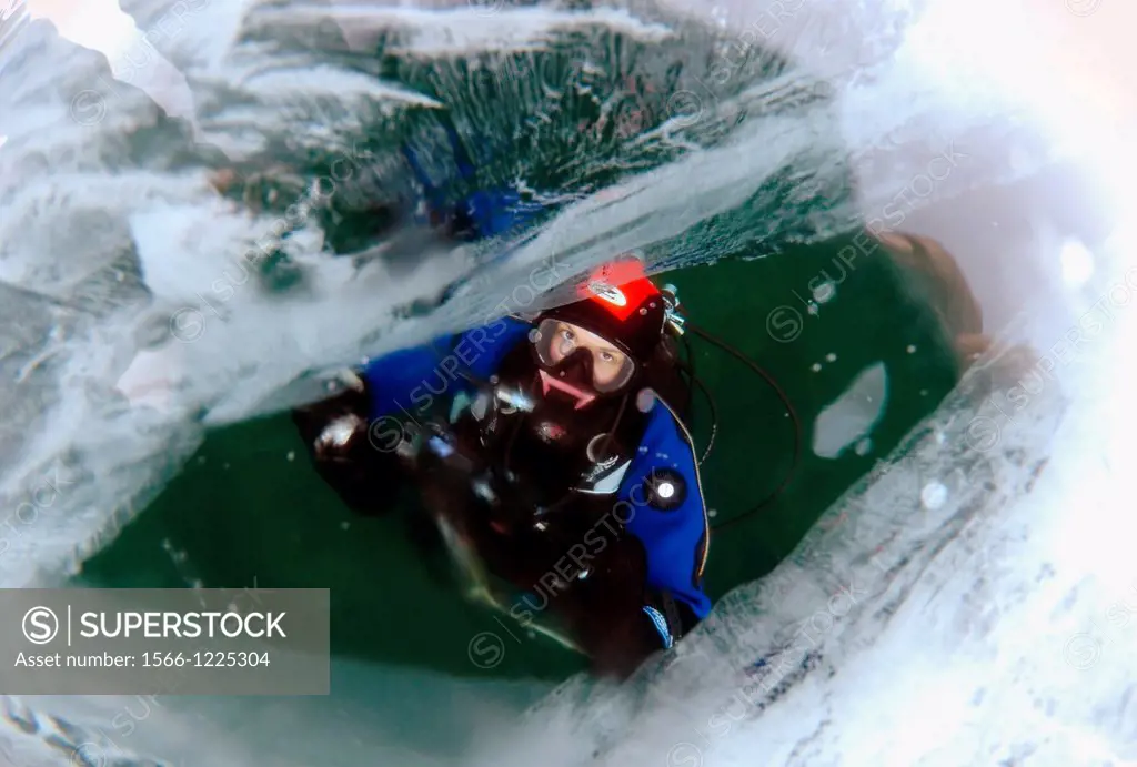 Diver looking through ice, Lake Baikal, Olkhon island, Siberia, Russia, Eurasia