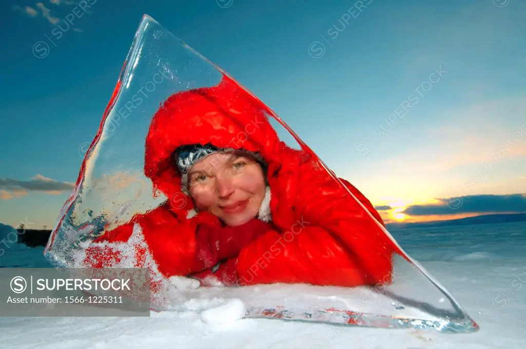 Woman looks through ice, Lake Baikal, Siberia, Russia, Eurasia