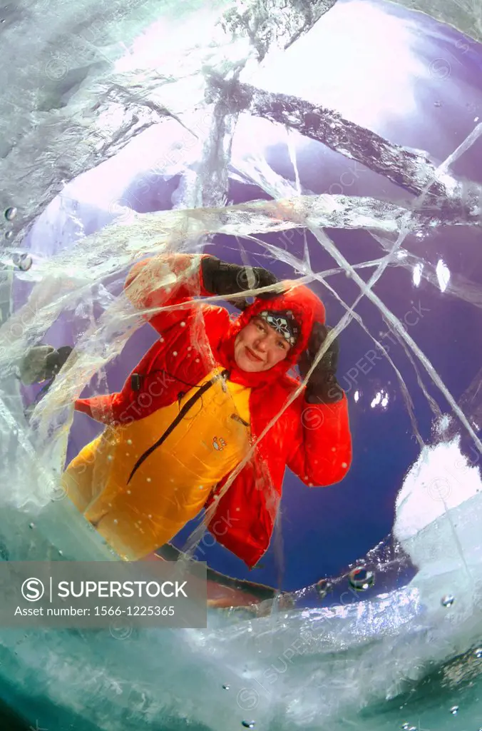 The woman looks through ice  lake Baikal, Siberia, Russia, island Olkhon