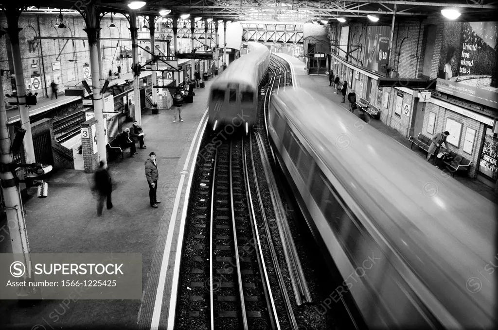 People on a platform of a train station. London, England