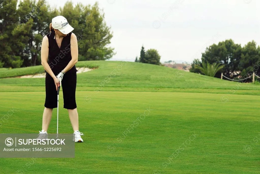 Woman playing golf, with the putt.