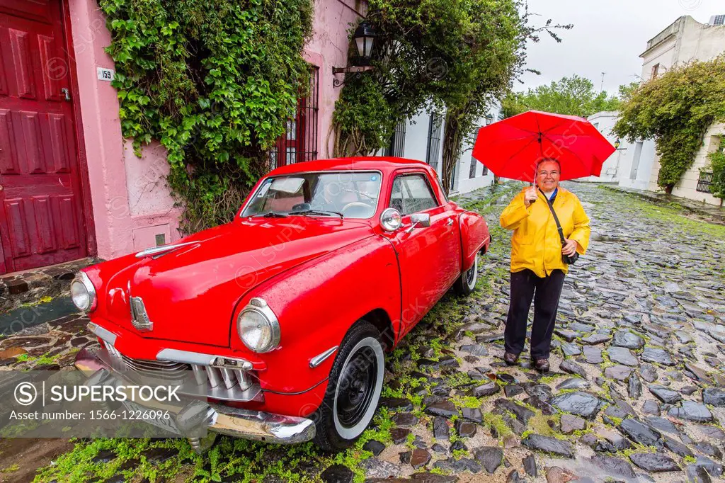 Lindblad guest with old Studebaker on cobblestone street in Colonia del Sacramento, Uruguay
