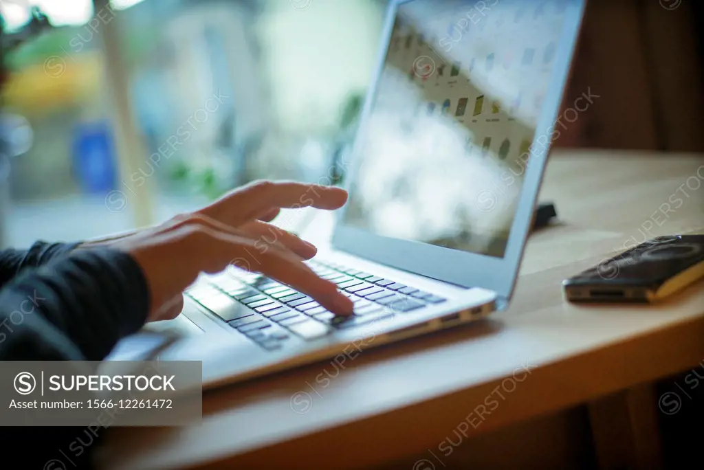 Closeup of female hands working with a laptop on a table in a cottage in Yorkshire Dales, England, UK